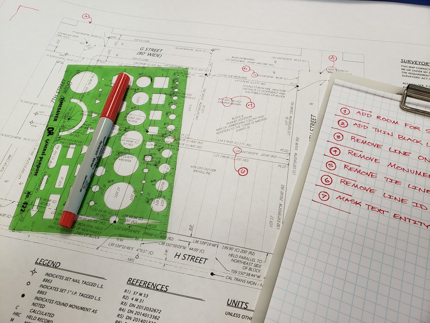 Architekturpläne auf einem Schreibtisch mit einer Schablone und einem Stift.